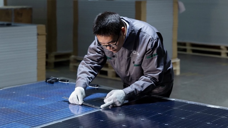 Worker inspecting solar panel